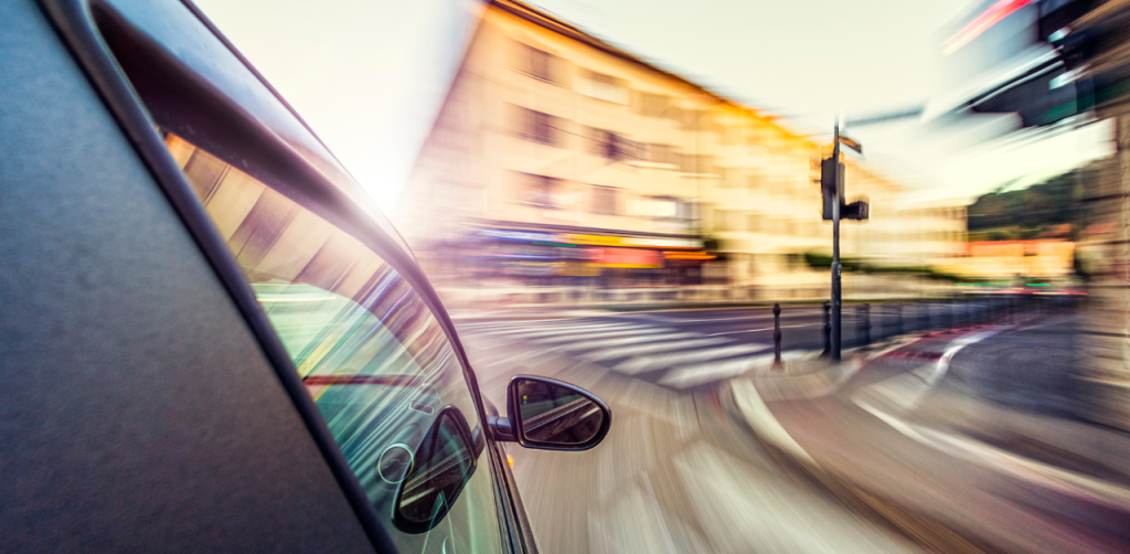 Car speeding through a city intersection, blurred motion capturing speed and urban environment