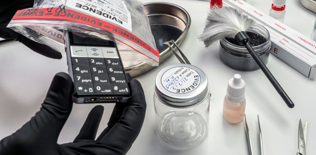 Forensic investigator documenting mobile phone evidence at crime scene lab