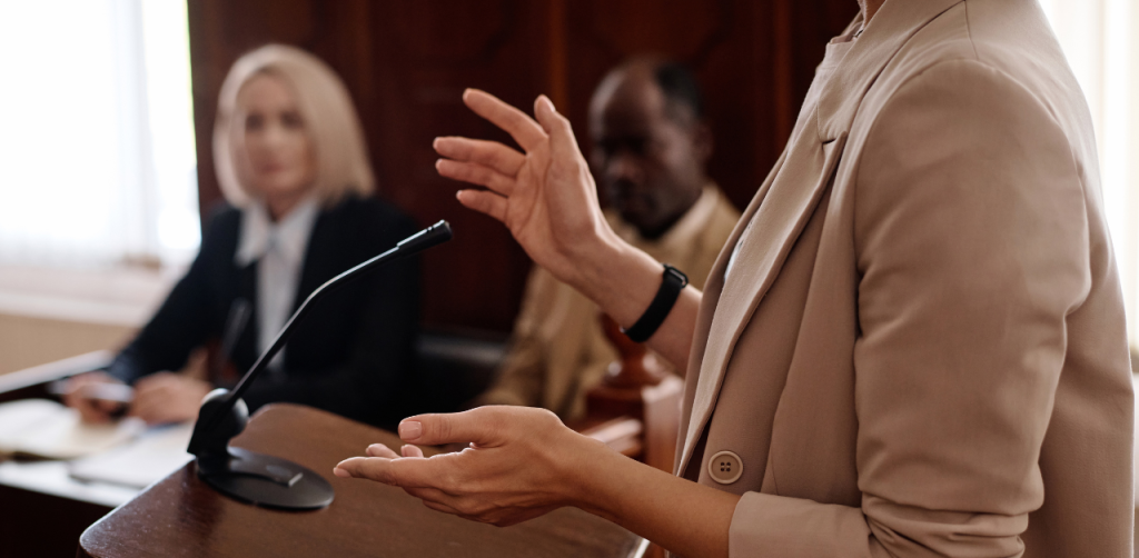 Lawyer speaking in courtroom while others listen