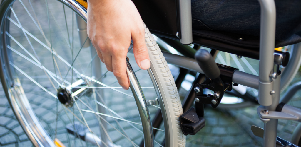 Close-up of person using wheelchair, gripping wheel for mobility and independence