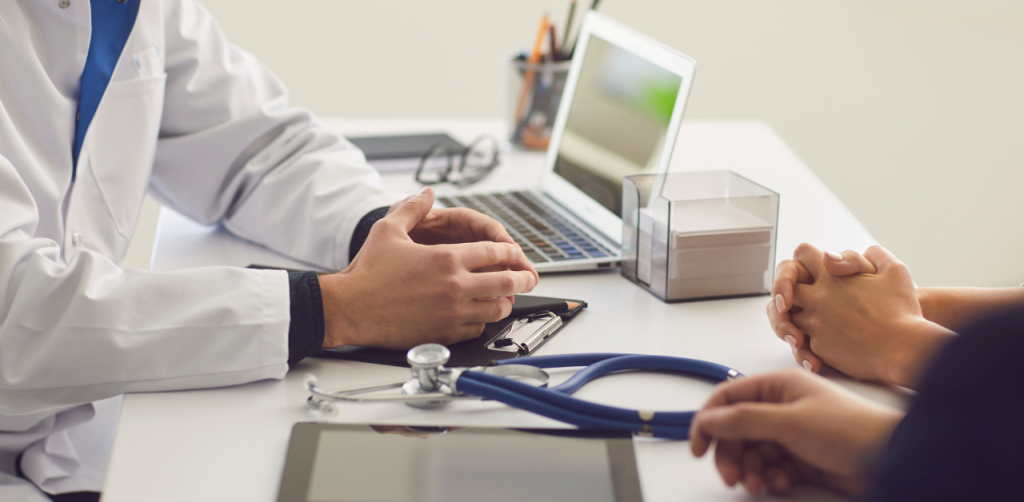 Doctor consulting patient in office during injury claim evaluation
