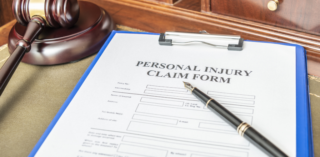 Personal injury claim form on a clipboard next to a judge’s gavel, highlighting legal action and compensation