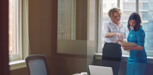 Two businesswomen reviewing documents during office consultation