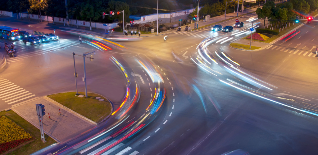 Busy intersection at night with light trails from moving vehicles