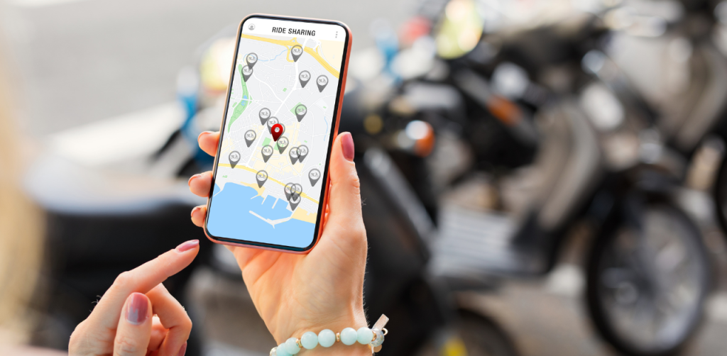 Woman using a ride-sharing app on her phone near parked scooters, representing transportation options and legal concerns after an Uber or Lyft accident in Las Vegas