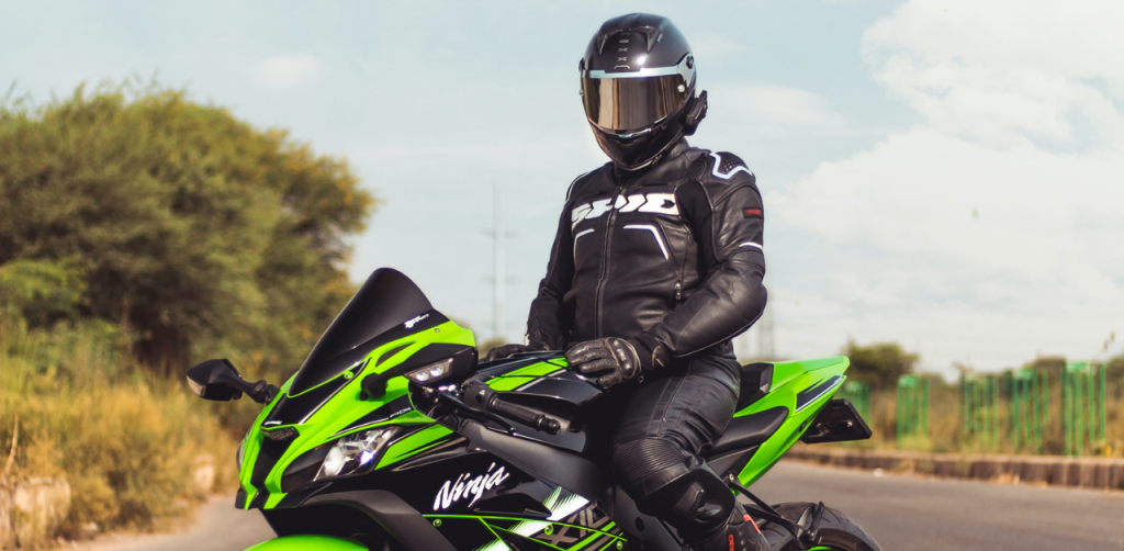 Motorcyclist in full gear on a green sport bike, emphasizing safety before a motorcycle accident