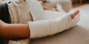 Person resting with a bandaged arm on a couch, representing injury recovery and Casino Escalator Accident Claims