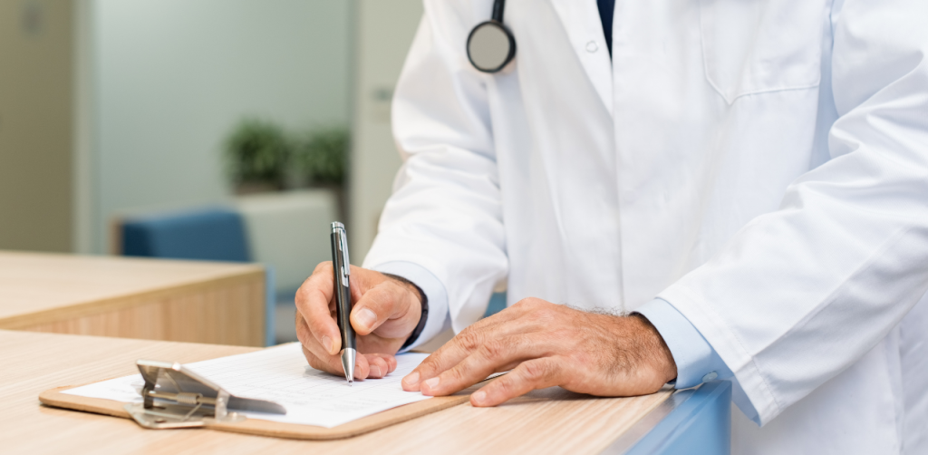 Doctor filling out a medical form on clipboard