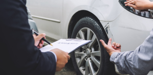 Insurance agent inspects car damage after crash, documenting incident tied to pedestrian safety