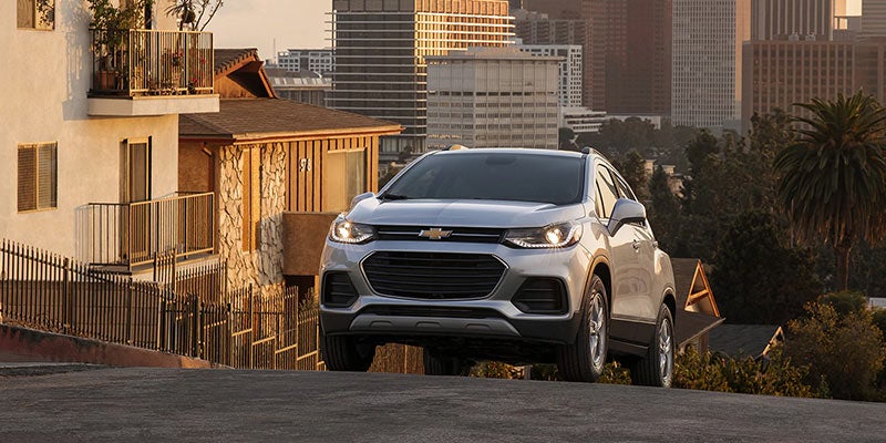 Light-colored Chevrolet SUV parked near a building.