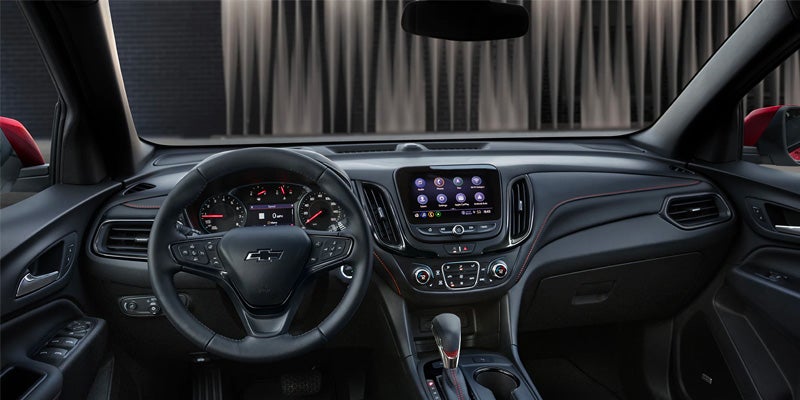 Dashboard view of a modern car interior with a steering wheel, instrument cluster, and touchscreen display.