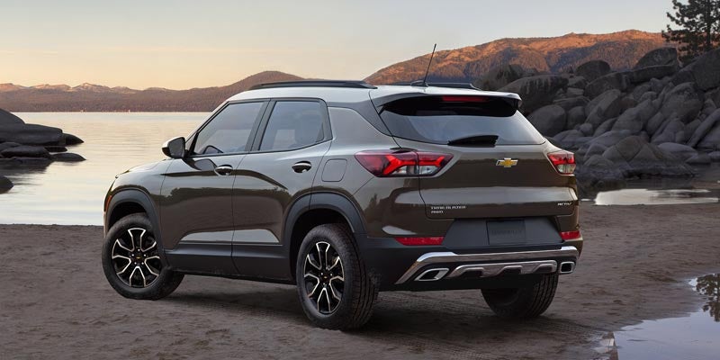 A bronze 2022 Chevy Trailblazer is shown from the side driving past a lake after leaving a Chevy dealer in Allentown, PA.
