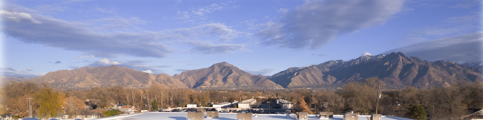 Wasatch mountains above a Mark Miller Subaru roofline