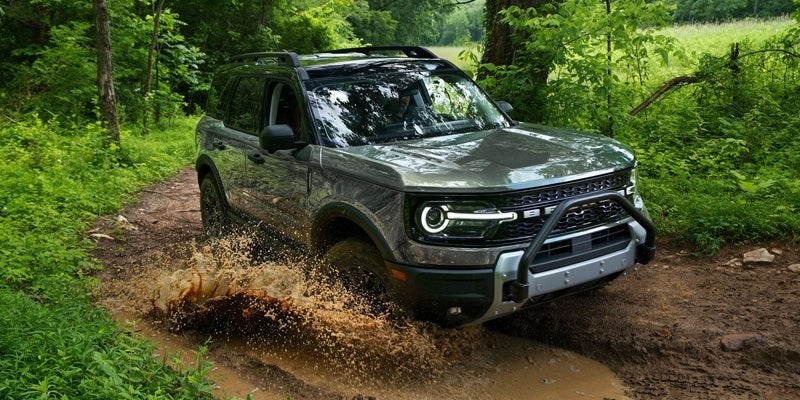 Green 2026 Ford Bronco Sport splashing through a muddy trail