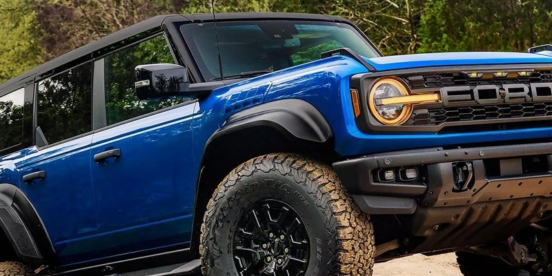 Blue Ford Bronco parked on a rocky trail