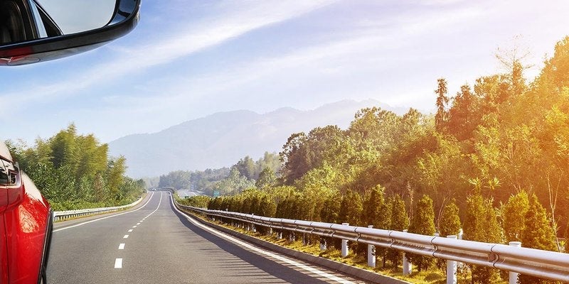 Car driving along an open highway in autumn