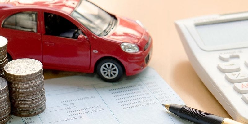 Model car beside a calculator and coins