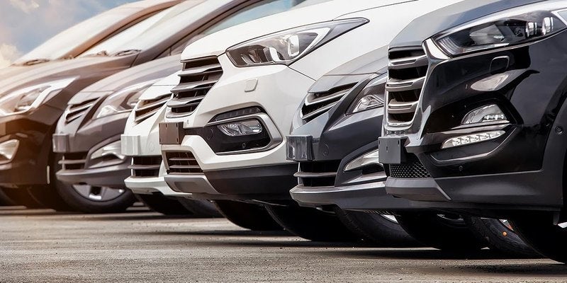 Row of vehicle front ends lined up on a dealership lot