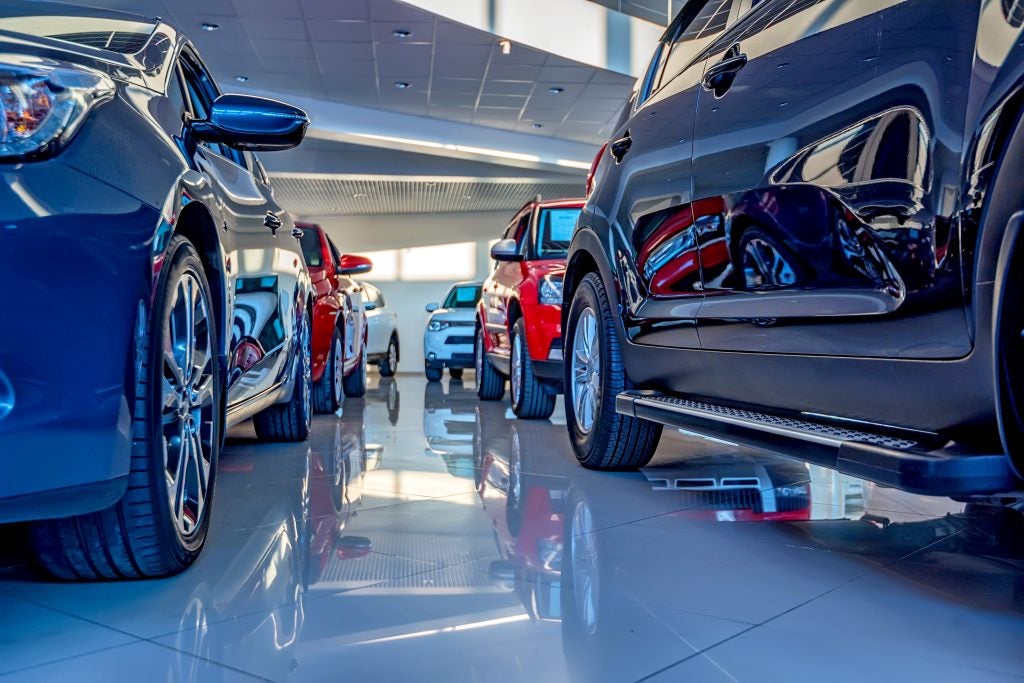 View of a car dealership showroom with various vehicles on display.