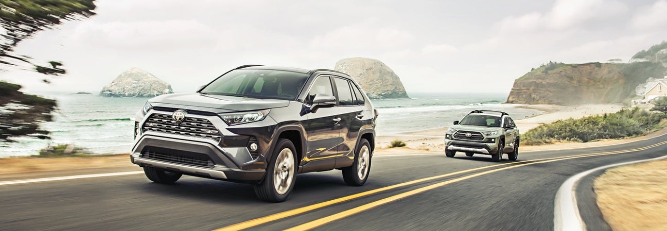 Black 2019 Toyota RAV4 driving oceanside highway
