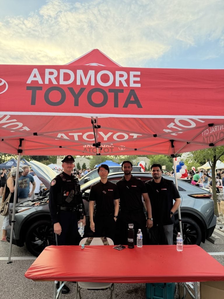 Ardmore Toyota representatives meeting with a local police officer during National Night Out at Suburban Square
