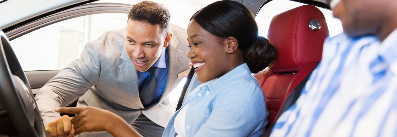 a car salesman helping two customers find the right car for them