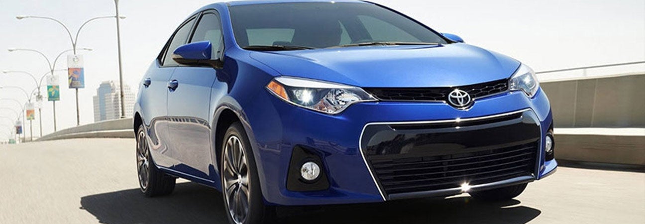 Blue Toyota Corolla cruising down the freeway