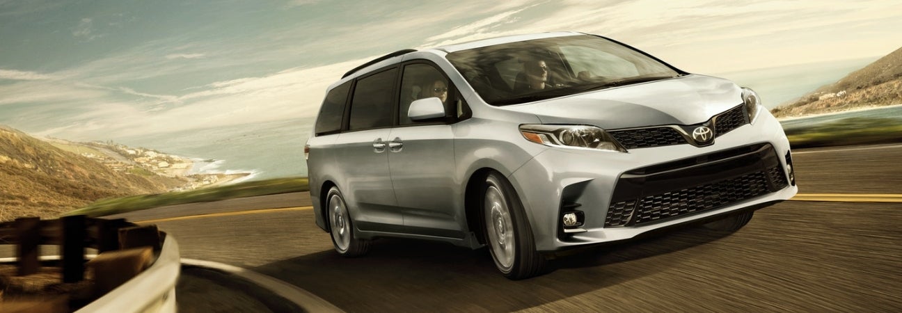 2019 Toyota Sienna in silver driving along a coastal highway
