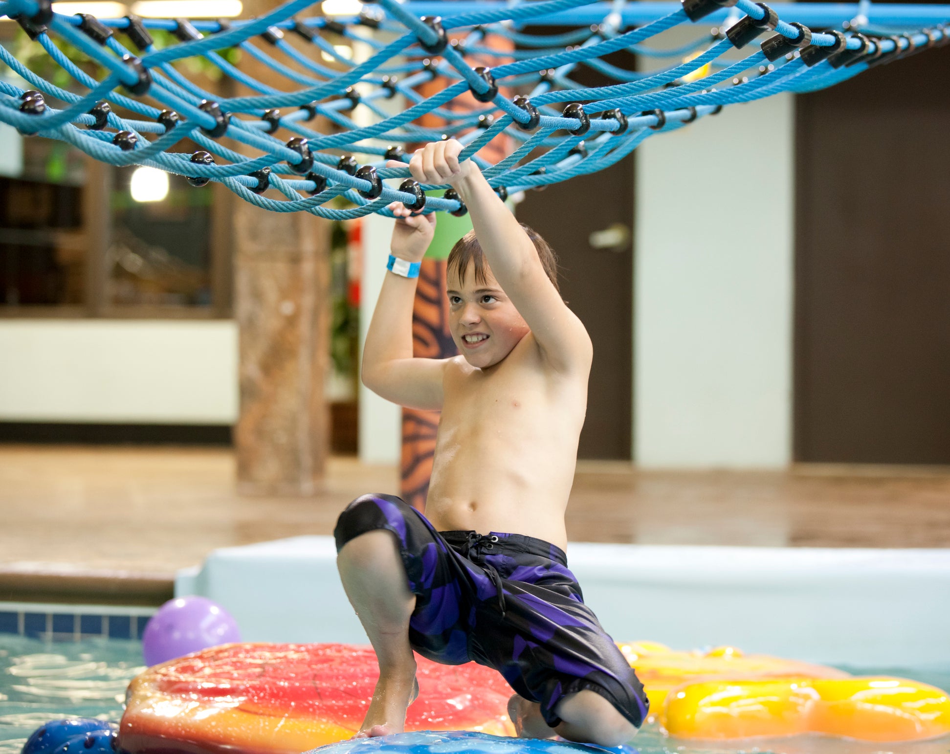 Young boy playing at the indoor water park