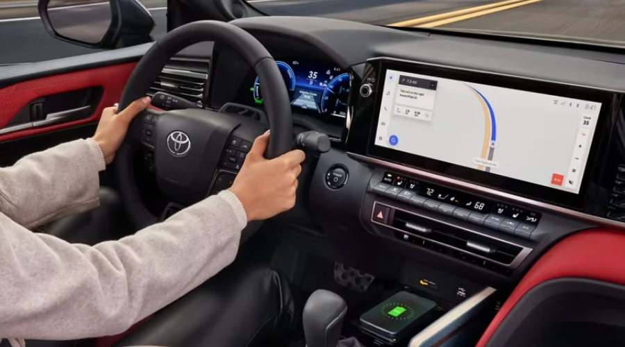 Driver steering a 2026 Toyota Camry featuring a 12.3-inch touchscreen multimedia navigation display, digital cluster, and climate defogging controls for comfortable wet weather driving in Waukegan, IL.