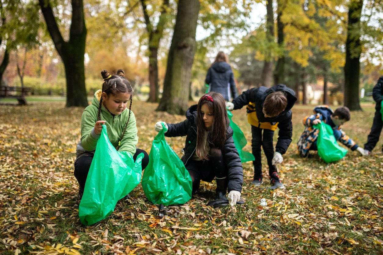 Kids collecting garbage in garbage bag while cleaning public park