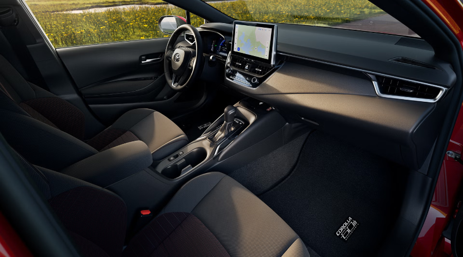 Spacious front cabin of the 2027 Toyota Corolla featuring two-tone fabric sport seats, central multimedia display with GPS navigation, and ergonomic dash design for commuters visiting Classic Toyota near Randolph