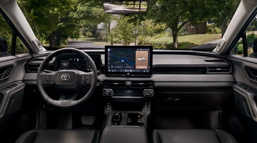 Interior steering wheel and center console view of a 2026 Toyota RAV4 showing tactile climate dials in Gurnee