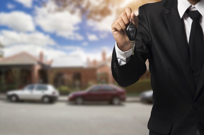businessman showing a car key - car sale &amp; rental business conce
