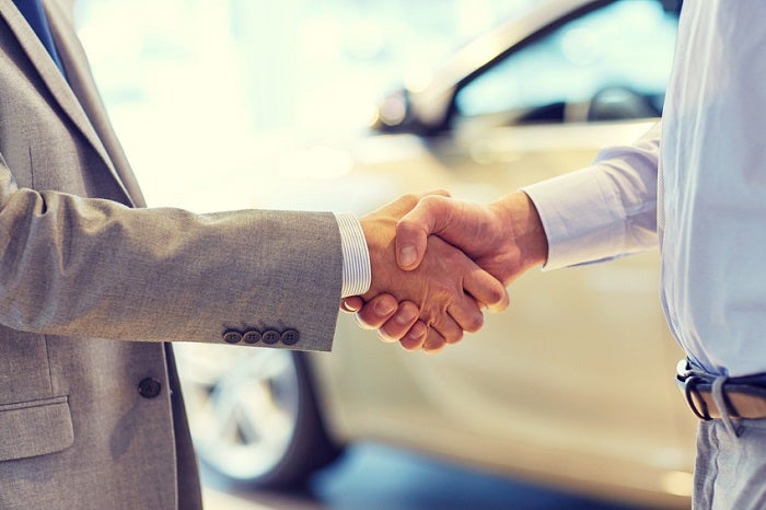 close up of male handshake in auto show or salon
