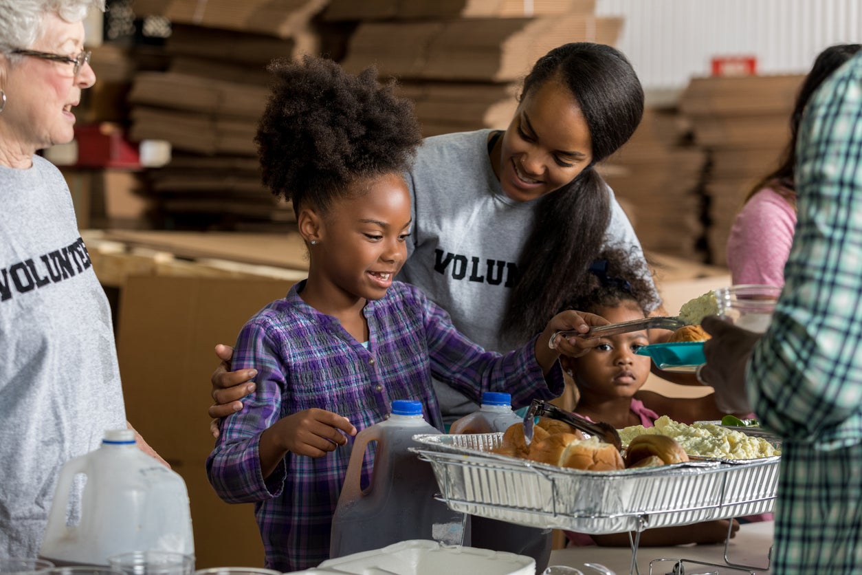 Diverse volunteers serve food in soup kitchen