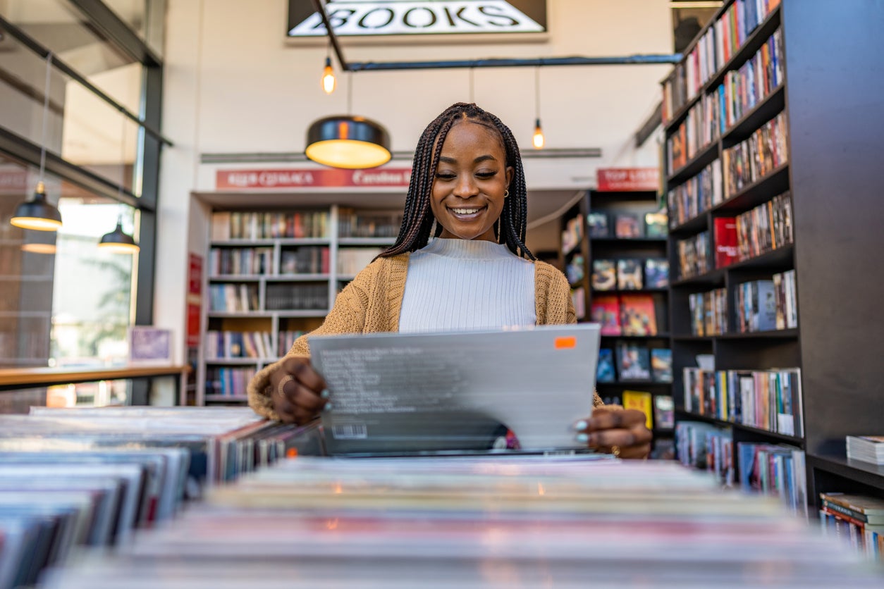 Woman with afro hair browsing vinyl records in a record store