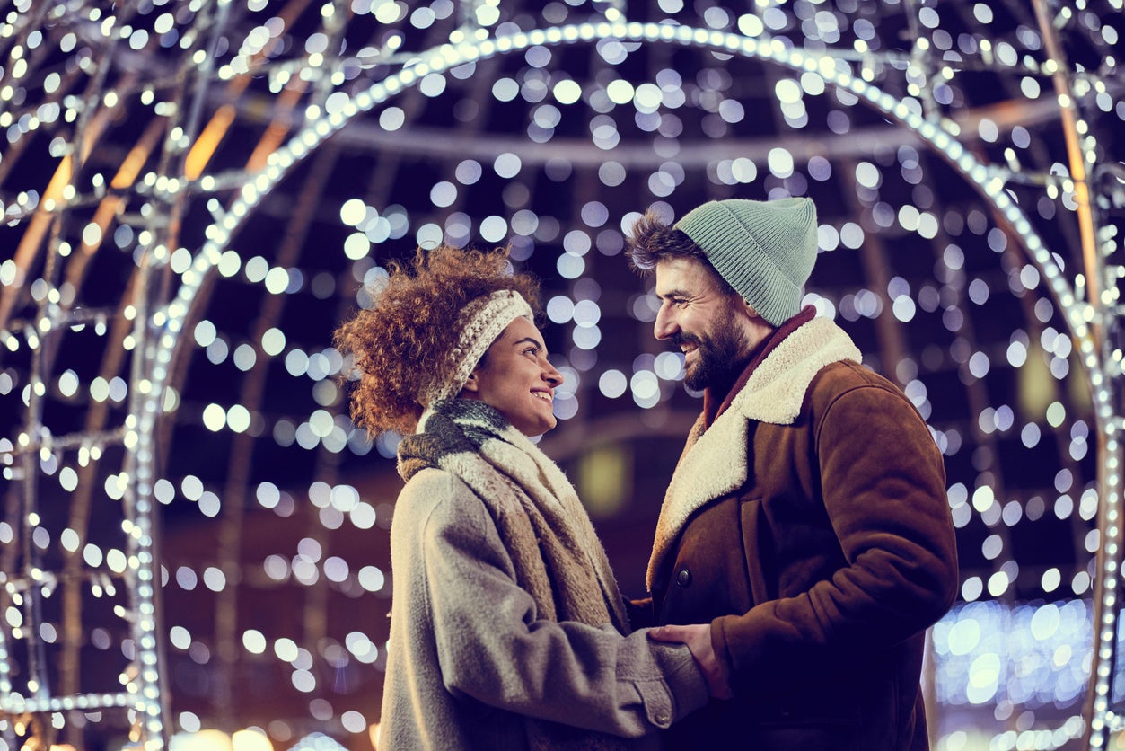 Happy couple talking during Christmas Eve on the street.