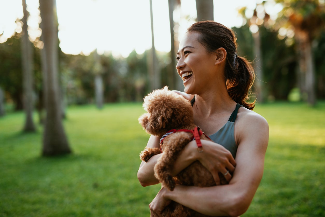 Beautiful Taiwanese sport woman with dog in the park