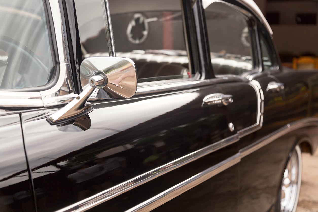 Black colored vintage classic American car parked on the street of Havana, Cuba. Retro car details.