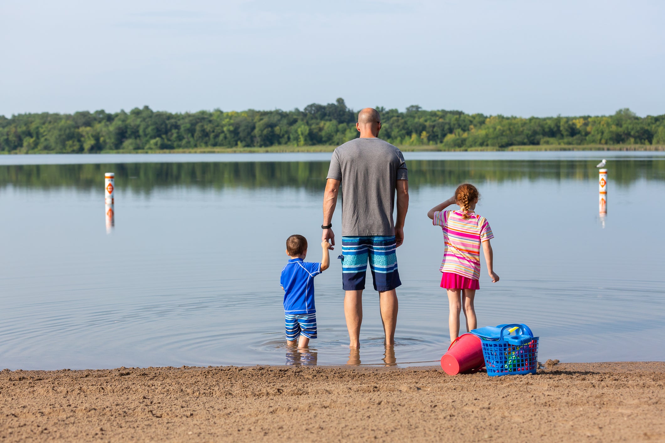 Father &amp; Two Children In Shallow Water At Beach