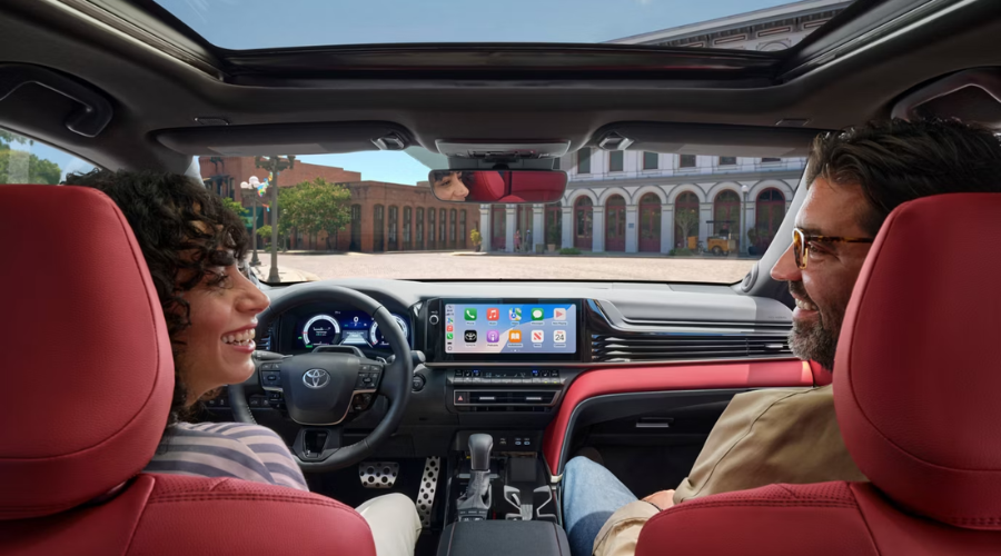 Interior cabin of the 2026 Toyota Camry featuring red leather upholstery and the 12.3-inch multimedia touchscreen display during a drive through Waukegan, IL