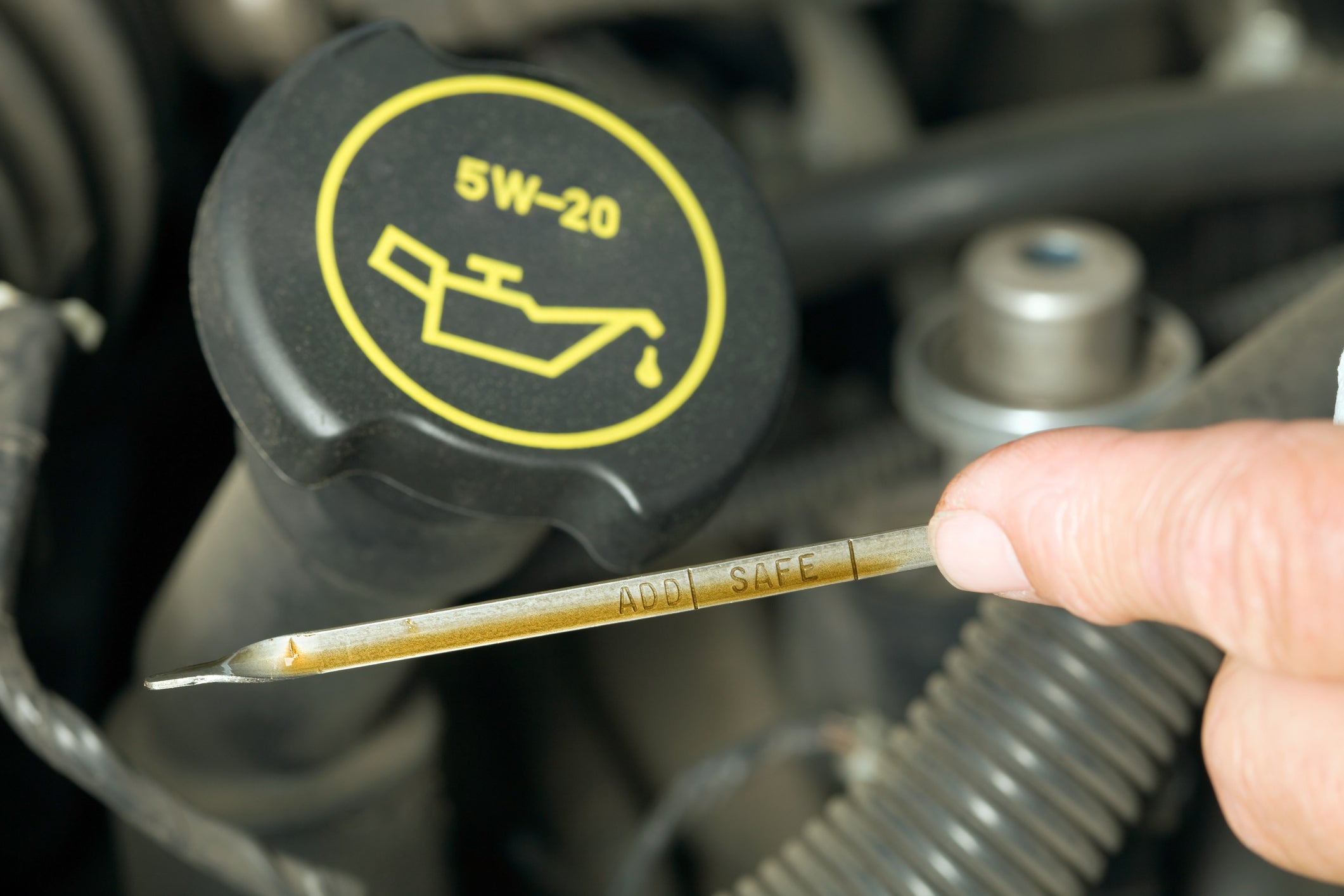 Male Finger Checking Oil Level on a Dipstick