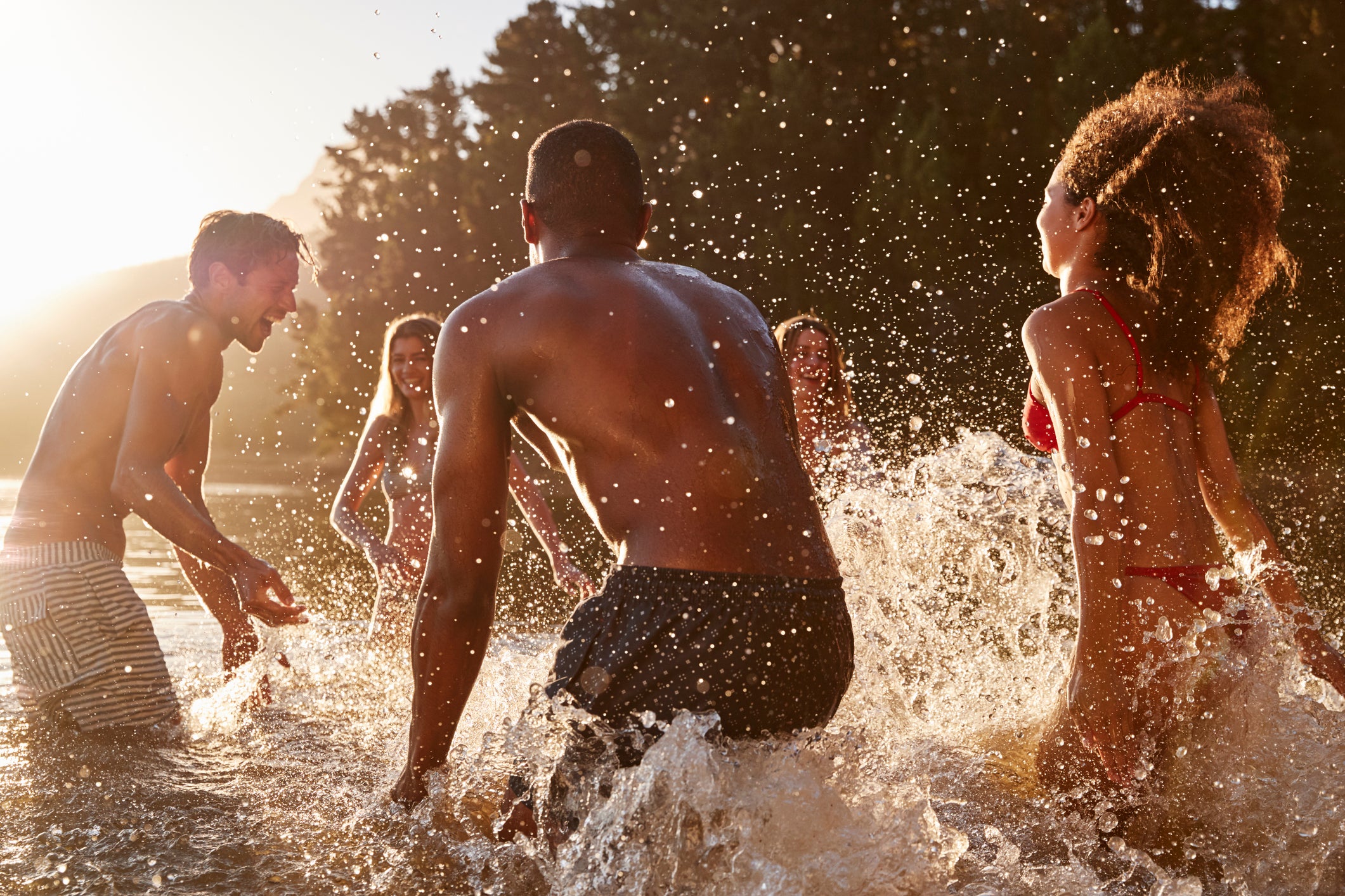 Young adult friends on vacation splashing in a lake