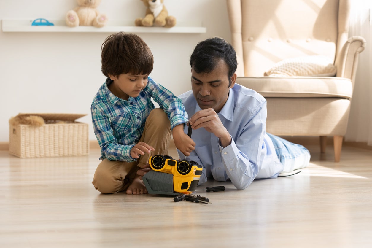 Indian father and small son repair toy car together