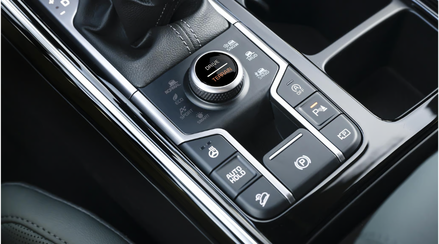 Close-up of the 2026 Kia Sorento center console featuring the rotary Drive Mode and Terrain Mode selector dial with Snow, Mud, and Sand settings, plus heated steering wheel and Auto Hold buttons for autumn driving in Waukegan and Gurnee, IL.