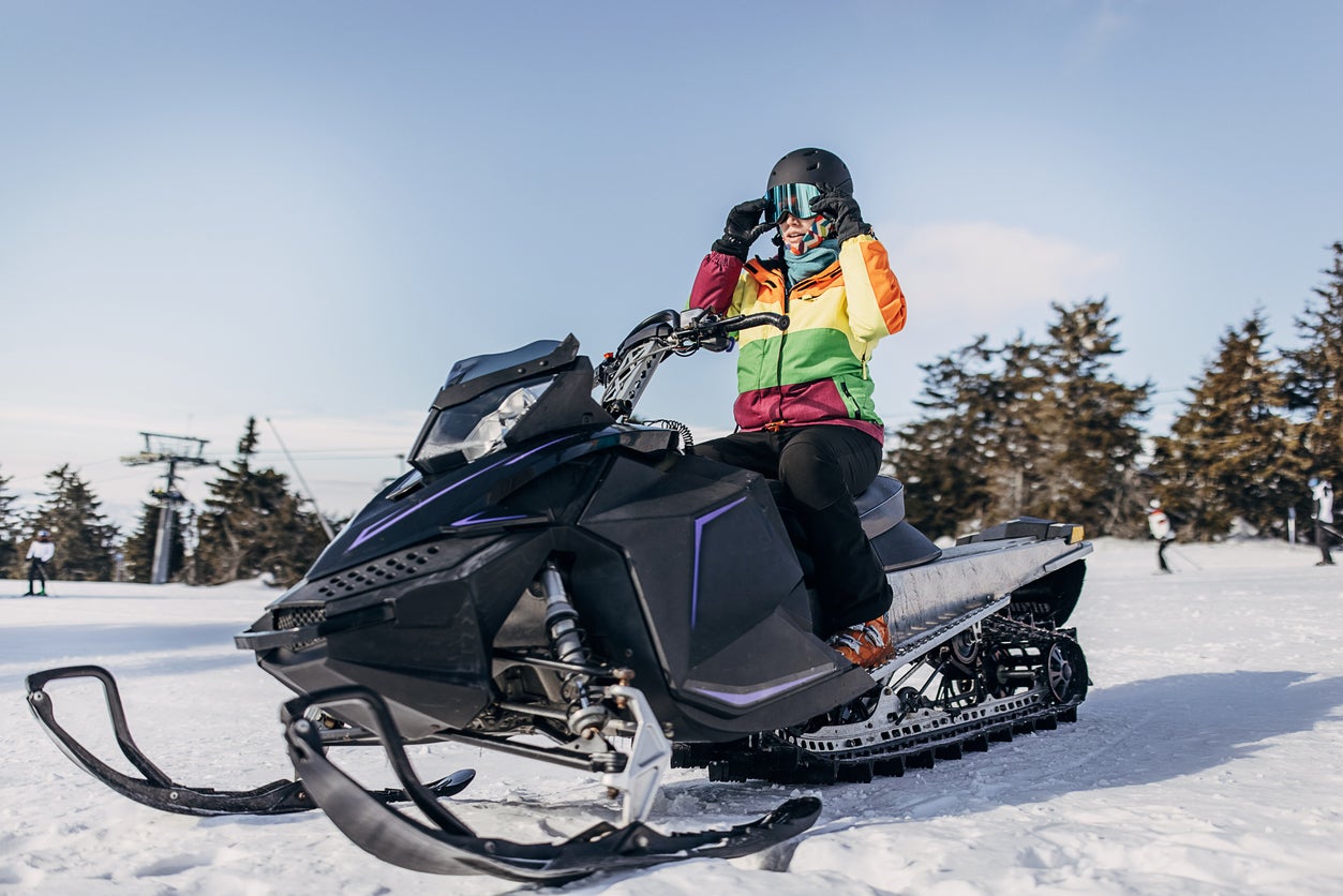 Woman sitting on snowmobile