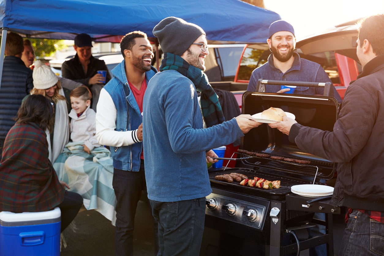 Group Of Sports Fans Tailgating In Stadium Car Park