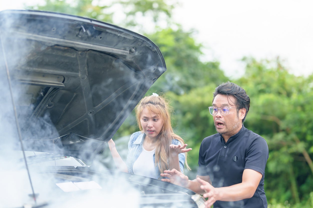 Road victims are shocked after an accident with smoking a car engine. on the road by a broken car in the middle of nowhere Smoke coming out of the engine needs help service tow truck service.