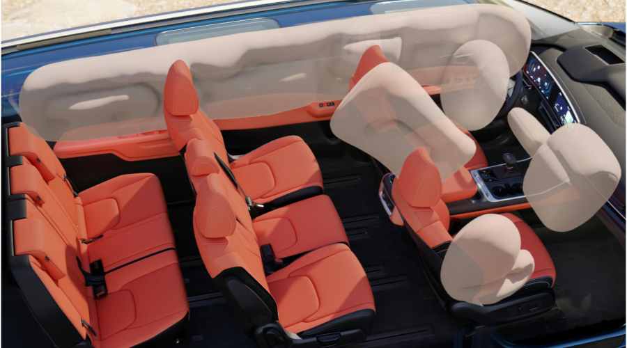 Cutaway graphic of the 2027 Kia Carnival three-row interior illustrating full-length side curtain airbags and front center airbags deployed over terracotta seats, highlighting family safety technology at Classic Kia serving Waukegan and Libertyville, IL.